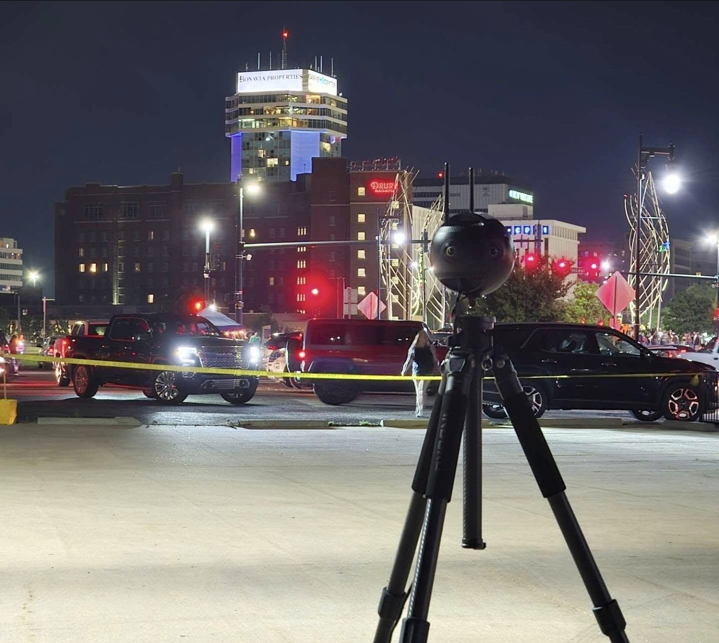 A 360 camera on a tripod at Riverfest in downtown Wichita at night