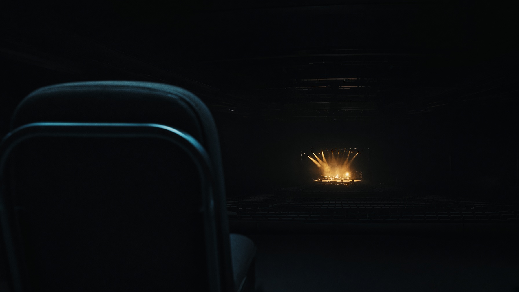 An empty arena seat facing a distant stage